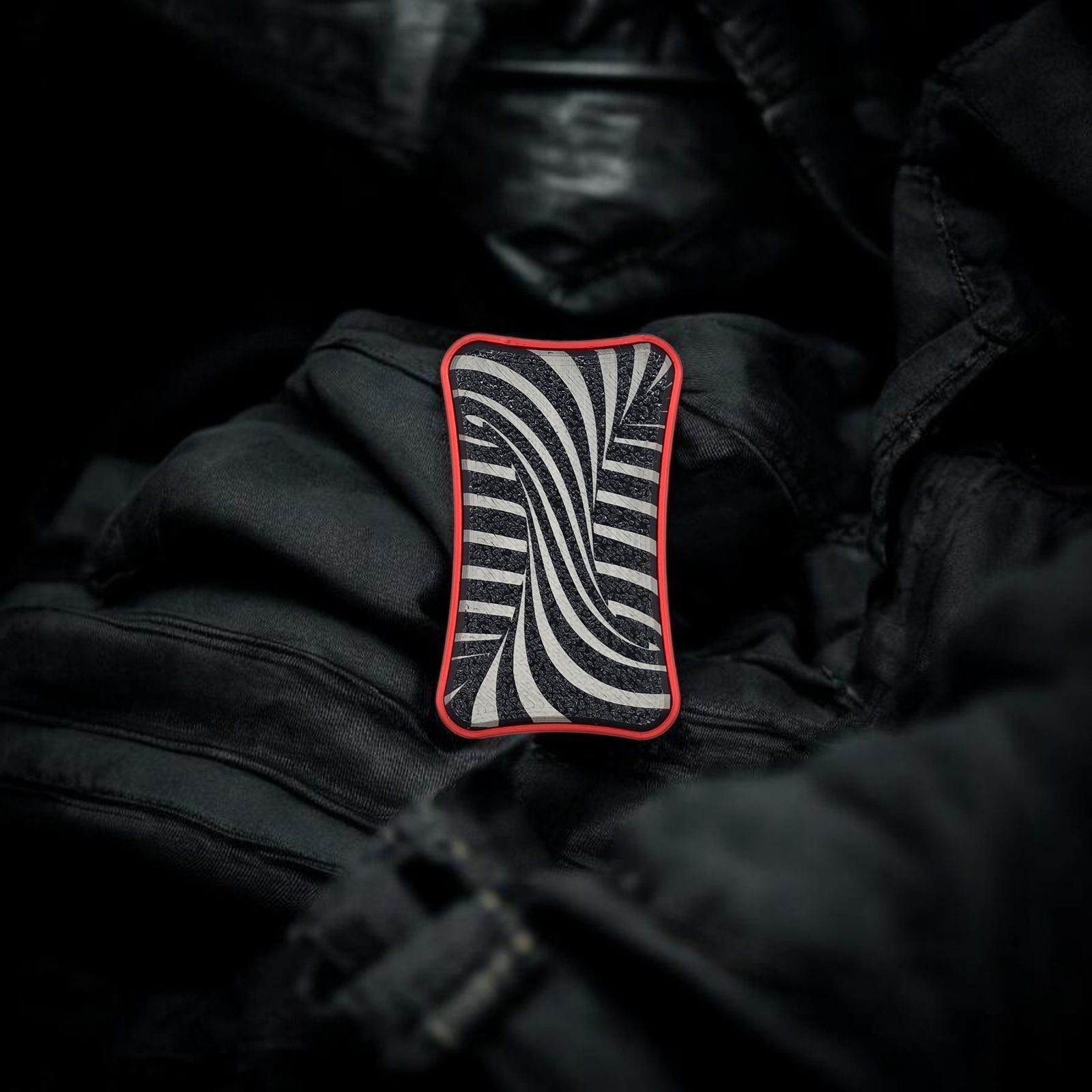 Vortex Slider magnetic fidget with swirl lids on black fabric